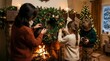 © pattaphorn - Family Decorating a Christmas Wreath Together by the Fireplace in a Cozy Holiday Living Room