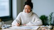 © Lightning - Creative asian woman artist painting on canvas in bright home studio wearing cozy white sweater