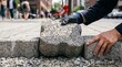© True Stock - Construction worker places interlocking paving stones on a sidewalk outdoors