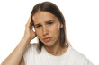 © vladimirfloyd - Portrait of a young woman with headache, hand on head, frustrated expression, on white background