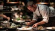 © Opi - Chef plating gourmet food with fresh herbs during busy restaurant service with warm ambient lighting