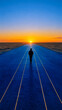© Esmari - Lone man walking on a blue road towards a glowing sunset
