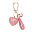 © Jittiwan - Luxury charm features 3D pink heart shape and looped strap encrusted with small crystals and a tiny gold heart badge with 'love' text connected with a carabiner via key ring on white background