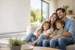 © Shock0991 - Happy young family relaxing together on a sofa in a modern bright living room looking away