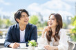 © maaagram - テラスカフェで笑い合う日本人カップルのデートシーン