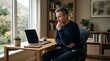 © Aulus - Focused man working on laptop in home office sitting by sunny window