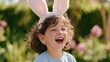 © World of AI - Child wearing bunny ear headband laughs joyfully outdoors in a garden filled with vibrant flowers and greenery, showcasing a playful springtime atmosphere