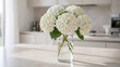 © Ame - white hydrangea flowers in a clear glass vase standing on a countertop in a kitchen