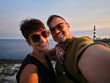 © Alvaro Lavin/Stocksy - Happy couple taking selfie near Far des Cap d'Artrutx lighthouse