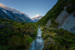 © dachakrapan - Hiker on a valley track walking toward Aoraki Mount Cook at first light, New Zealand