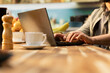 © DC Studio - Man works from home on a laptop at a kitchen table, combining online tasks and digital multitasking with a casual remote-worker routine in natural light.