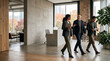 © fadiyah - Professional Colleagues Walking Together Through Modern Office Hallway Discussing Work Strategy