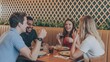 © Sakawat - Friends enjoying drinks and conversation together at the wooden table in a restaurant.