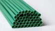 © Thares2020 - A bundle of green paper straws arranged in a neat stack on a plain white surface  showcasing their cylindrical shape and uniform color