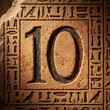 © miss irine - Stone carving displays number ten surrounded by ancient Egyptian hieroglyphs and symbols. Carved text and art on sandy beige rock surface. Historic cultural heritage artifact.