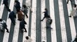 © animonday - Dynamic high-angle view of a diverse group of urban professionals and commuters briskly crossing a busy city zebra crossing, capturing the energetic pulse of modern life