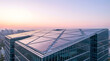 © MAHFUJA - Modern solar panels installed on a contemporary skyscraper rooftop at sunrise, representing renewable energy, sustainable urban architecture, green building technology, and clean power generation solu