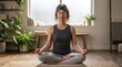 © Александр Янковский - Calm woman meditating in lotus pose wearing smart neurofeedback headband sensor at home
