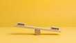 © twc - A conceptual wooden seesaw balance scale contrasting text blocks labeled needs and wants on a minimalist vibrant solid yellow background studio