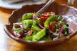 © k_samurkas - Freshly prepared salad with tomatoes, cucumbers, and herbs in a rustic bowl