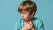 © 69 - Young boy coughing and holding hand on throat showing signs of sore throat and discomfort feeling unwell in teal shirt