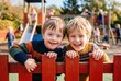 © Lumen Harbor - Happy boys smiling behind playground fence