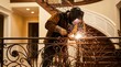 © Stock Spectrum - Skilled craftsman welding ornate wrought iron railings for a residential staircase with decorative designs.