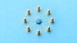 © abusuhail - Blue central wooden figure connected to surrounding beige figures representing leadership and networking