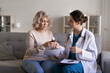© fizkes - Doctor consulting to senior woman, giving pills bottle, explain medication dosage, discussing treatment plan, provide professional medical services during housecall visit. Healthcare, pharmacology