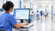 © Mohammad Al-amin - Female nurse in blue scrubs using a computer to review electronic health records