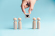 © Manasanan Wongchoomp - Education selection concept with hand choosing graduation symbol above wooden people, representing student admission, scholarship, academic opportunity, recruitment and future learning.