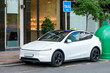 © scharfsinn86 - White electric taxi car with roof sign parked on a city street