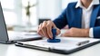 © Zarana  - Businessman in a suit stamping a legal document or contract on a desk in an office. Corporate approval and notary concept for legal services.