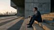 © iQbal Esmoyr - Thoughtful Businessman Sits on Steps Overlooking Cityscape at Sunset.