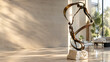 © Kavin - Abstract metal sculpture of two human figures connected by flowing forms in a modern interior with dramatic natural light
