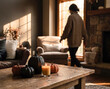 © Rendara Studio - Woman in cozy sweater walking toward sunlit window past halloween pumpkin coffee table