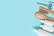 © Firn - Hair care and styling products arranged on blue background with copy space