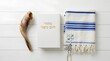 © Hazar - Jewish religious symbols including a shofar, Machzor prayer book, and blue and white tallit prayer shawl.