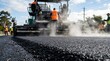 © BrilliantPixels - An artistic portrait of the road paving process with a heavy machine emitting a plume of steam.