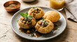 © Misbah - Pani puri with chickpeas and mint garnish on a speckled plate