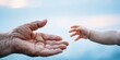 © Bonsales - Elderly hand reaching toward baby hand, symbolizing human connection, generations, care, and support