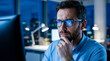 © SIRAJ - Focused businessman working on computer in office at night