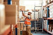 © peopleimages.com - Man, box and shelf in warehouse for distribution, storage management and organizing for efficiency. Supervisor, package and order in facility for logistics, supply chain and stock control in business