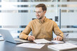 © Liubomir - Financial planning and business analysis, professional man working with laptop and calculator in modern office. Corporate employee reviewing data and managing budget strategy.