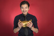 © LaDieuNgoc - Smiling businessman holding a golden Chinese ingot for wealth and prosperity