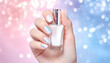 © CatNap Studio - Winter & Festive Nail Art Glamour: Feminine hand holding luxury cosmetic bottle with manicure serum in elegant serene mood