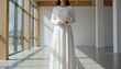 © QuoDesign - Hispanic woman wearing a blank white long sleeve dress in a sunny museum atrium