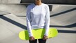 © QuoDesign - Slender Asian woman wearing a blank white long sleeve shirt holds a skateboard near a stone skatepark