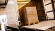 © Video80X - Pallet of stacked cardboard boxes wrapped in plastic on a truck lift gate inside a loading dock, logistics and freight shipping concept.