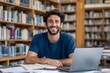 © dex - Happy Male Student with Laptop and Books in Library Portrait